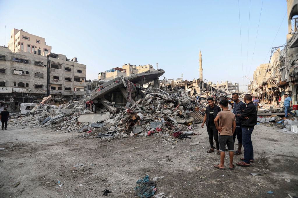 Palestinos inspeccionan los restos de edificios destruidos provocados por los ataques aéreos israelíes en Ciudad de Gaza, el sábado 28 de octubre de 2023. 