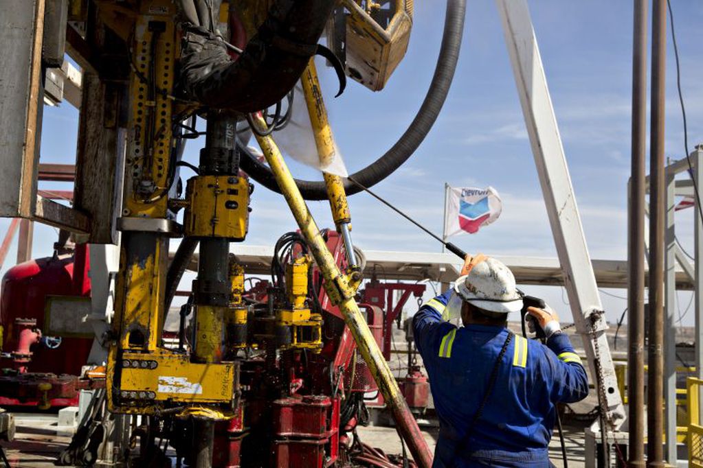 A Nabors Industries Ltd. roughneck uses a power washer to clean the drilling floor of a rig drilling for Chevron Corp. in the Permian Basin near Midland, Texas, U.S., on Thursday, March 1, 2018. Chevron, the world's third-largest publicly traded oil producer, is spending $3.3 billion this year in the Permian and an additional $1 billion in other shale basins. Its expansion will further bolster U.S. oil output, which already exceeds 10 million barrels a day, surpassing the record set in 1970. Photographer: Daniel Acker/Bloomberg eeuu  obras de la empresa Chevron el tercer mayor productor de petroleo del mundo expansion de la empresa petrolera plataforma petrolera impulsara mas aun la produccion de petroleo