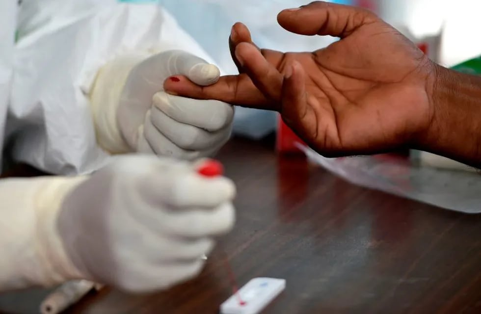 Medical staff conduct a blood sample test for the COVID-19 coronavirus on a person arriving from a red zone, at a community health centre in Samahani, Aceh province on June 5, 2020. (Photo by CHAIDEER MAHYUDDIN / AFP)