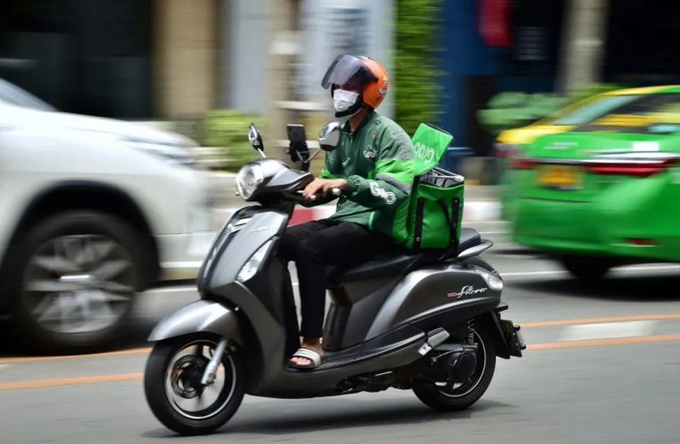 This photo taken on May 4, 2020 shows a Grab Food delivery driver in Bangkok, as the volume of online food orders have soared since the stay home restrictions were put in place to fight the COVID-19 coronavirus. - Gourmet take-out delivered by a butler in a black sedan -- Thailand's super-rich have not forgone luxury during a pandemic which has locked the country down, crushed the economy and left millions unemployed. (Photo by Lillian SUWANRUMPHA / AFP) / TO GO WITH Health-virus-Thailand-social,FOCUS by Dene-Hern Chen