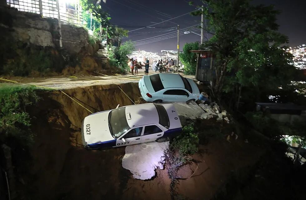 Dos coches a punto de caer en un barranco por el sismo que sacudió Acapulco y otras ciudades mexicanas. (EFE/David Guzmán).