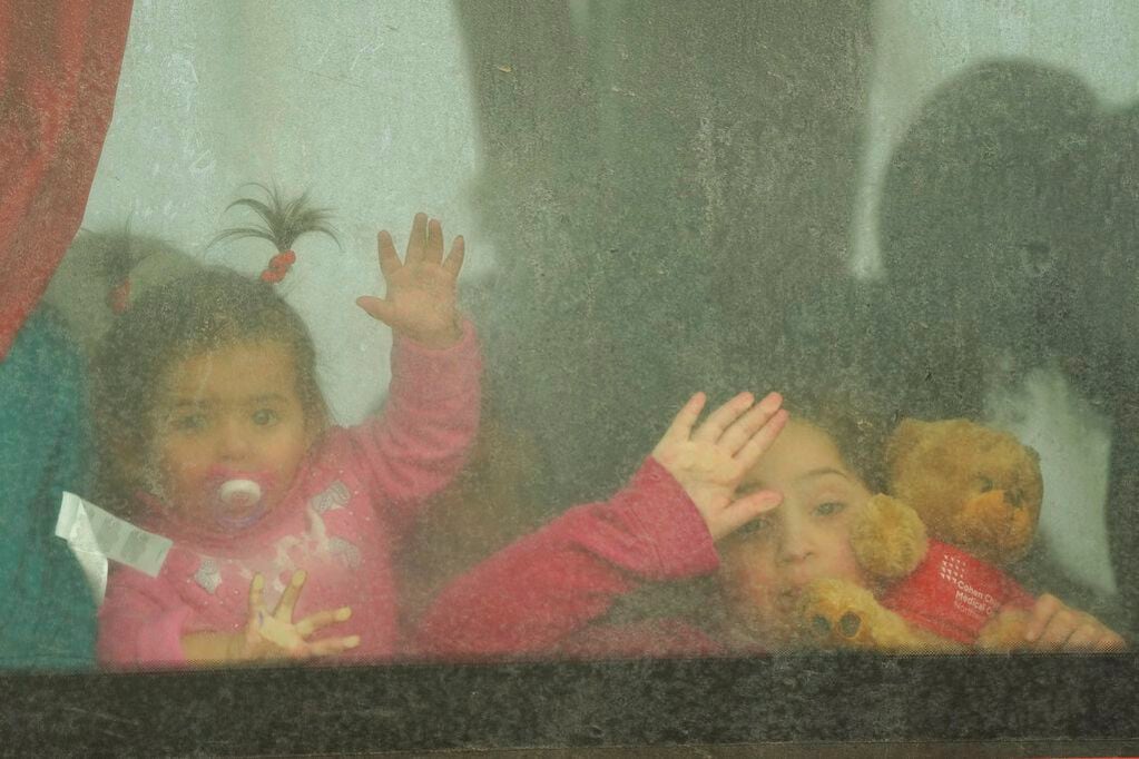 Niños refugiados se asoman por la ventana de un autobús que va rumbo a Rumania después de huir de la guerra en Ucrania.