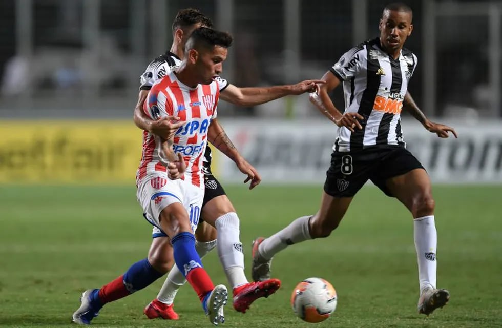 Brazil's Atletico Mineiro midfielders Hyoran and Jair (R) vie for the ball with Argentina's Union de Santa Fe midfielder Horacio Carabajal during their 2020 Copa Sudamericana football match at Independencia Stadium, in Belo Horizonte, Brazil, on February 20, 2020. (Photo by DOUGLAS MAGNO / AFP)
