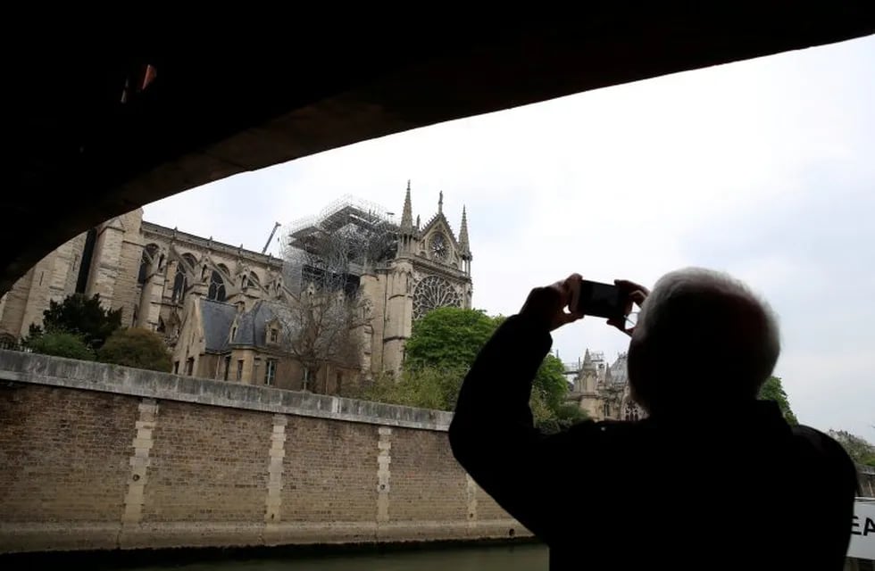 A man takes pictures of Notre-Dame Cathedral after a massive fire devastated large parts of the gothic gem in Paris, France April 16, 2019.
