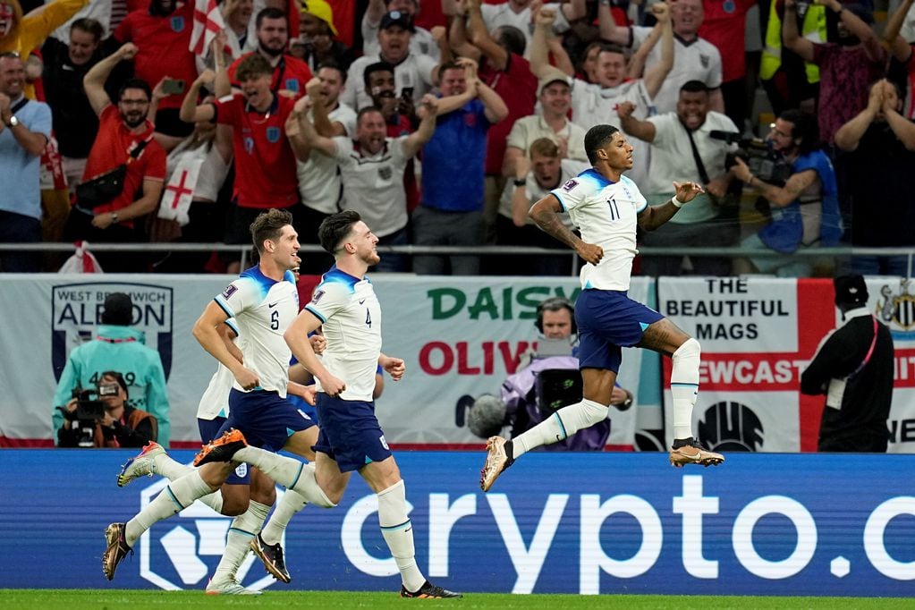 Festeja Inglaterra, festeja Marcus Rashford, autor del primer gol frente a Gales para asegurar el primer puesto en el grupo del Mundial de Qatar. (AP)