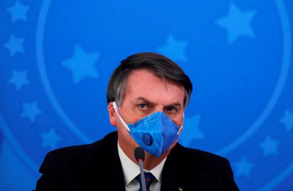 (FILES) In this file photo taken on March 20, 2020 Brazil's President Jair Bolsonaro wears a face mask during a press conference on the coronavirus pandemic COVID-19 at the Planalto Palace in Brasilia. - Brazil's COVID-19 death toll passed 15,000 on May 16, 2020, official figures showed, while its number of infections topped 230,000, making it the country with the fifth highest number of cases in the world. (Photo by Sergio LIMA / AFP)