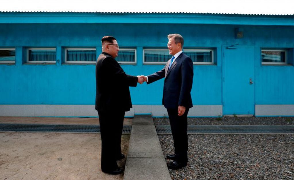 Kim y Moon se dan la mano en la Línea de Demarcación Militar que divide a ambas Coreas.
