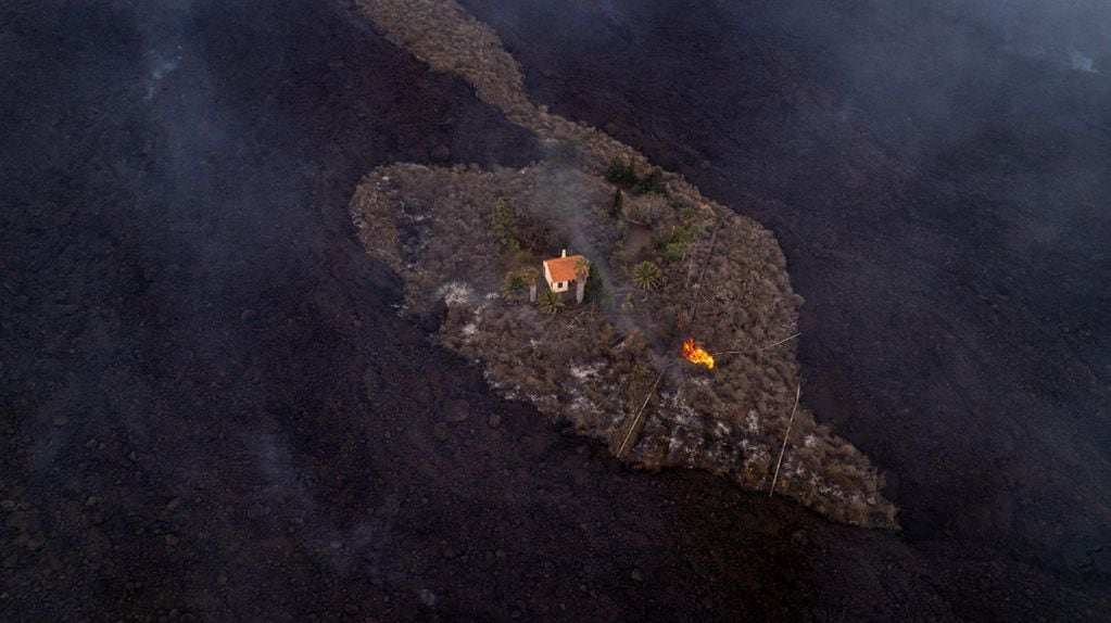 Una casa permanece intacta mientras la lava fluye a su alrededor . (AP)