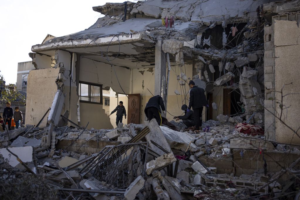 Palestinos revisan lo que quedó de una construcción tras un bombardeo israelí en Rafah, en la Franja de Gaza, el 21 de febrero de 2024. 