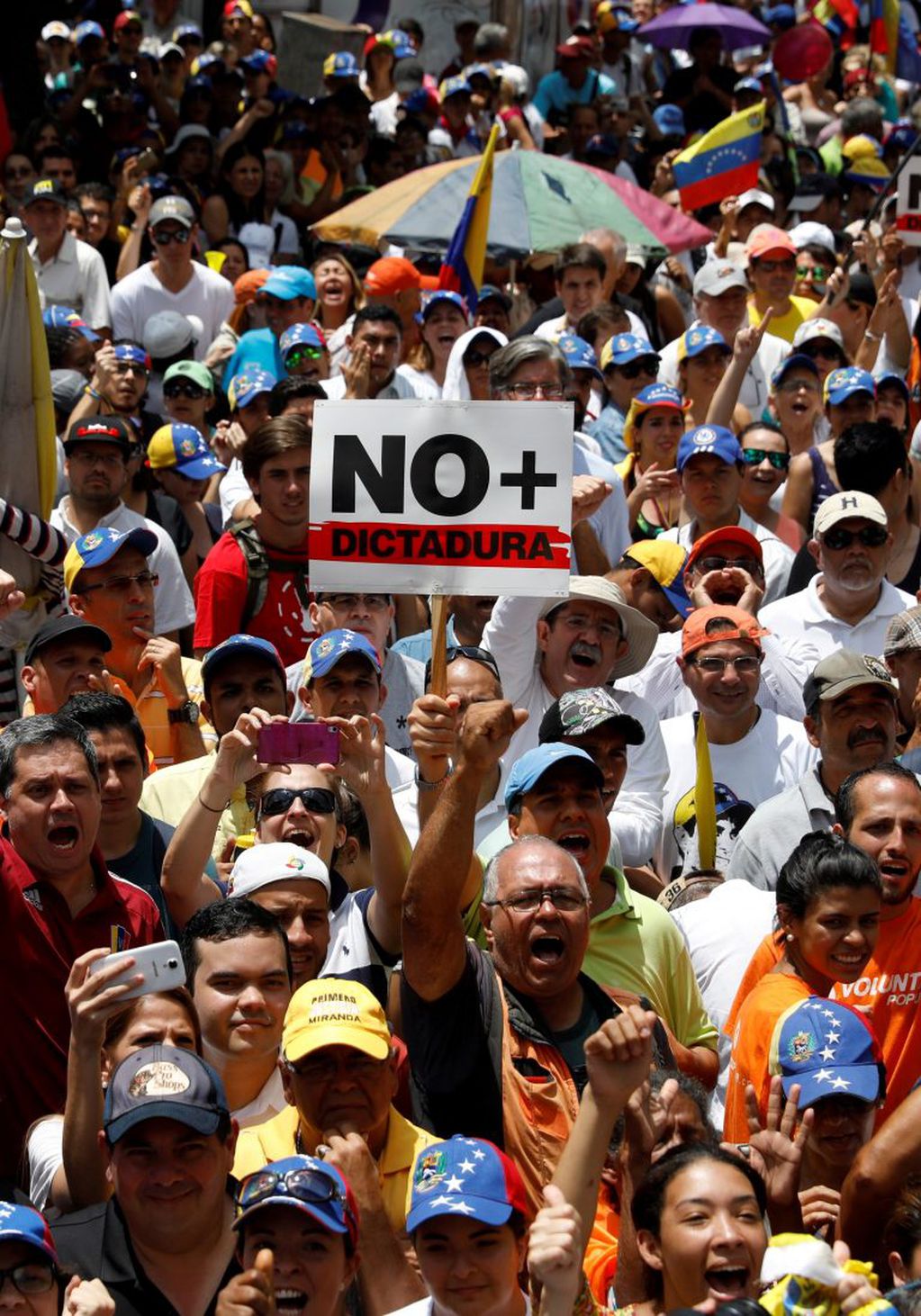 People participate in an opposition rally in Caracas, Venezuela, April 8, 2017.  The sign reads: "No more dictatorship". REUTERS/Carlos Garcia Rawlins