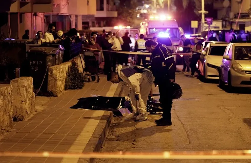 Las fuerzas de seguridad y los equipos de emergencia examinan un cuerpo que yace en las calles de Tel Aviv.