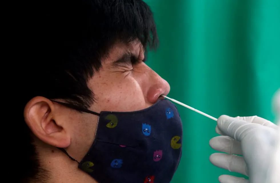 A healthcare worker collects a swab sample from a person at a coronavirus disease (COVID-19) testing site in Lima, Peru October 31, 2020. REUTERS/Sebastian Castaneda NO RESALES. NO ARCHIVES