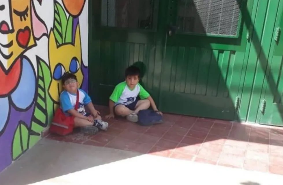 Los niños se quedaron sentados en la puerta del jardín porque las maestras no los dejaron entrar.