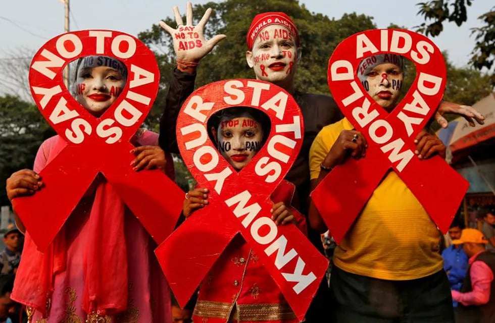 FILE PHOTO: People with painted faces hold ribbon cut-outs as they pose during an HIV/AIDS awareness campaign on the eve of World AIDS Day in Kolkata, India, November 30, 2018. REUTERS/Rupak De Chowdhuri/File Photo