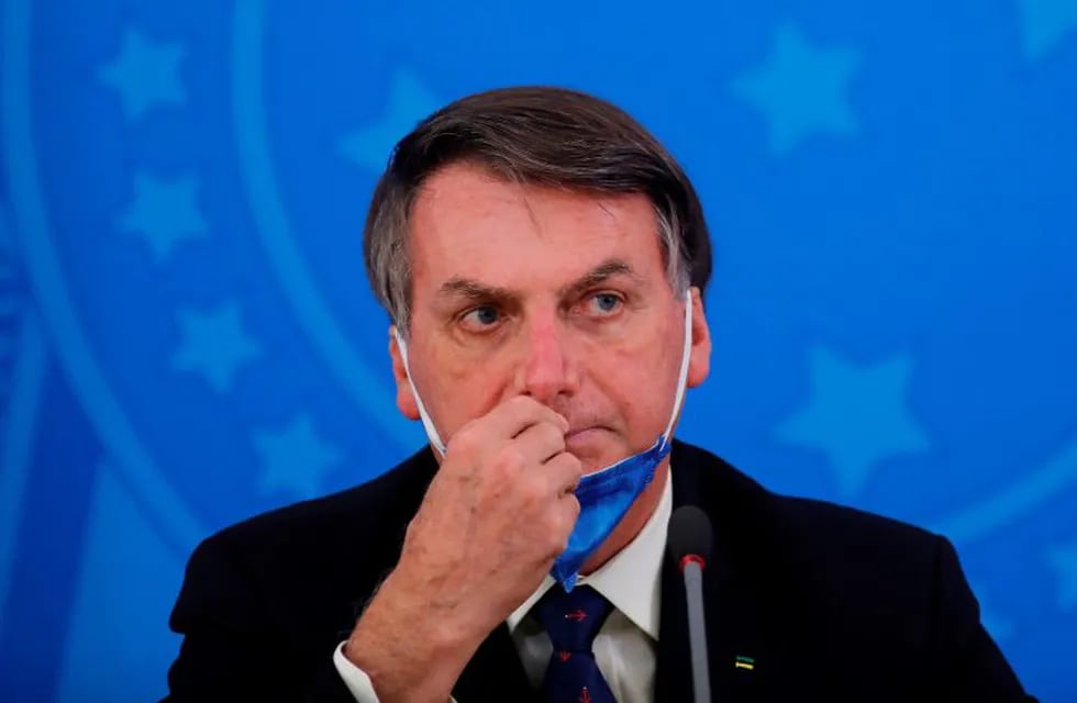 (FILES) In this file photo taken on March 20, 2020 Brazil's President Jair Bolsonaro gestures during a press conference on the coronavirus pandemic COVID-19 at the Planalto Palace in Brasilia. - Two tweets by Brazilian president Jair Bolsonaro in which he questioned quarantine measures aimed at containing the novel coronavirus were removed on March 29, 2020, on the grounds that they violated the social network's rules. The far-right leader had posted several videos in which he flouted his government's social distancing guidelines by mixing with supporters on the streets of Brasilia and urging them to keep the economy going. (Photo by Sergio LIMA / AFP)