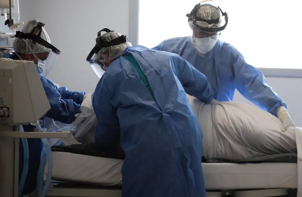 Doctors, dressed in full protective gear, attend to a patient in an intensive care unit designated for people infected with COVID-19, at the Posadas hospital in Buenos Aires, Argentina, Thursday, Sept. 17, 2020, amid the new coronavirus pandemic. (AP Photo/Natacha Pisarenko)  terapia intensiva casos del dia hospital posadas
