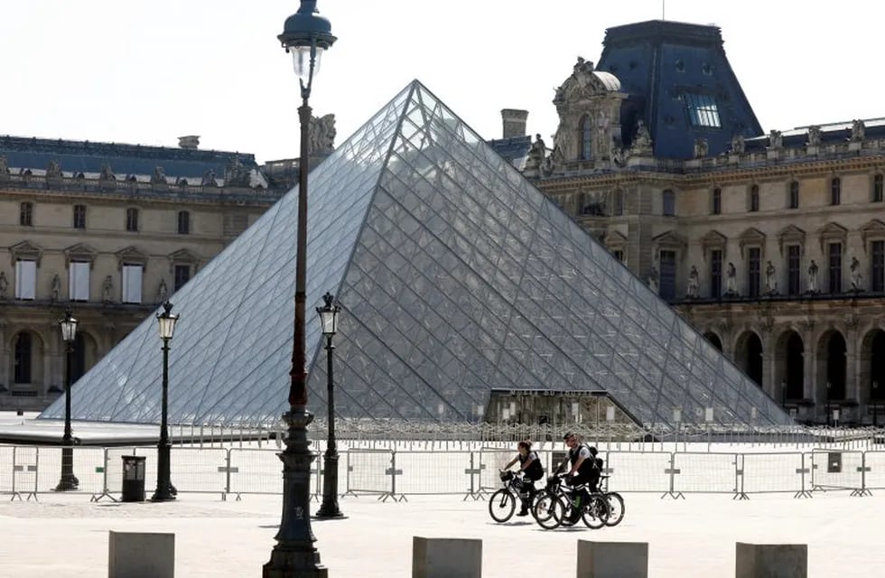 Policemen rides past the closed Louvre Pyramid designed by Chinese-born U.S. architect Ieoh Ming Pei as a lockdown is imposed to slow the rate of the coronavirus disease (COVID-19) in Paris, France, April 16, 2020. REUTERS/Charles Platiau