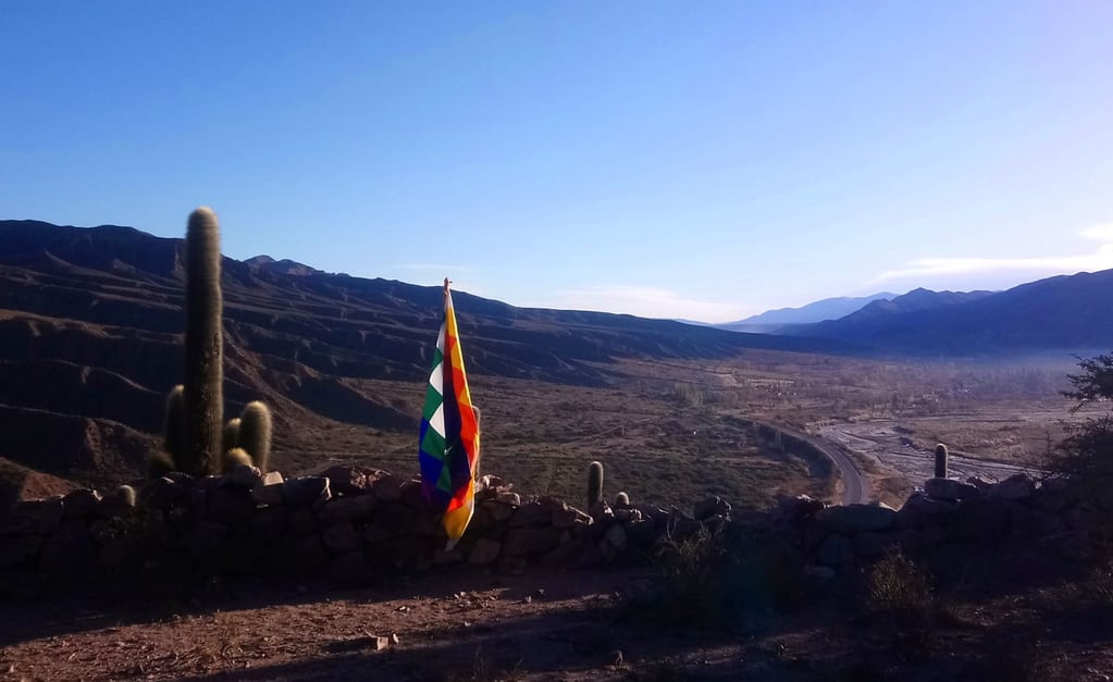 La whipala marca presencia en la espectacular geografía del Angosto de El Perchel, en el amanecer en la Quebrada de Humahuaca.