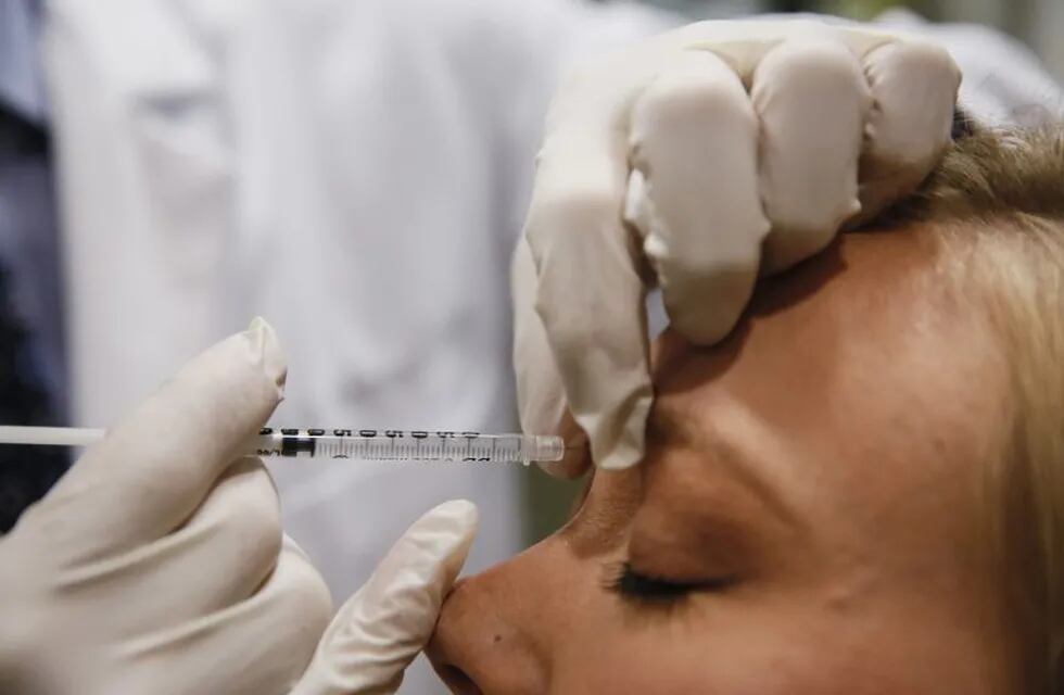 Dr. Keith A. Marcus injects Allergan Inc. Botox between a patient's eyes at the offices of Marcus Facial Plastic Surgery in Redondo Beach, California, U.S., on Tuesday, April 22, 2014. Valeant Pharmaceuticals International Inc. offered to buy Allergan Inc., maker of the Botox wrinkle treatment, in a cash-and-stock deal valued at $45.7 billion in the latest step of the Canadian company's plan to become one of the world's largest drugmakers. Photographer: Patrick T. Fallon/Bloomberg *** Local Caption *** Keith A. Marcus eeuu  medico inyecta Botox entre los ojos de un paciente cirugia plastica facial cirugias acuerdo compra fabricante de la arruga de Botox tratamiento
