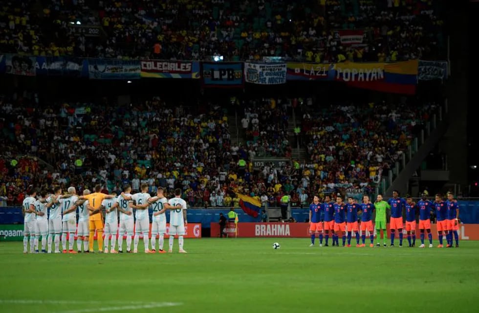 Players of Argentina (L) and Colombia pay tribute to Argentine sports journalist Sergio Gendler who died on June 13, before the start of their Copa America football tournament group match against Colombia at the Fonte Nova Arena in Salvador, Brazil, on June 15, 2019. (Photo by Juan MABROMATA / AFP)