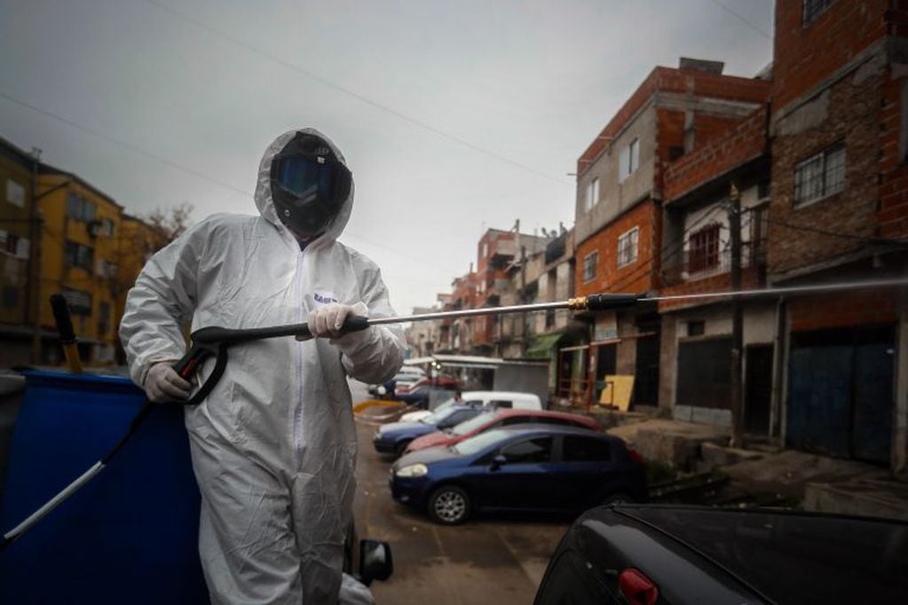 Un residente desinfecta un área como parte de la campaña de prevención contra la propagación del coronavirus en el barrio Padre Rodolfo Ricciardelli (Foto: EFE/Juan Ignacio Roncoroni)