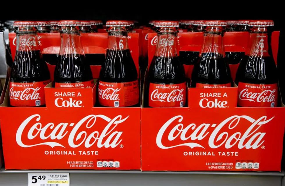 FILE--In this Aug. 8, 2018, file photo, bottles of Coca Cola sit on a shelf in a market in Pittsburgh. The Coca-Cola Company says that it's \