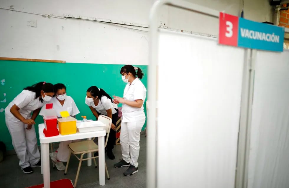 Enfermeras leen las instrucciones para inyectar las vacunas Sputnik V contra el COVID-19 en la escuela pública Bernal, a las afueras de Buenos Aires, Argentina