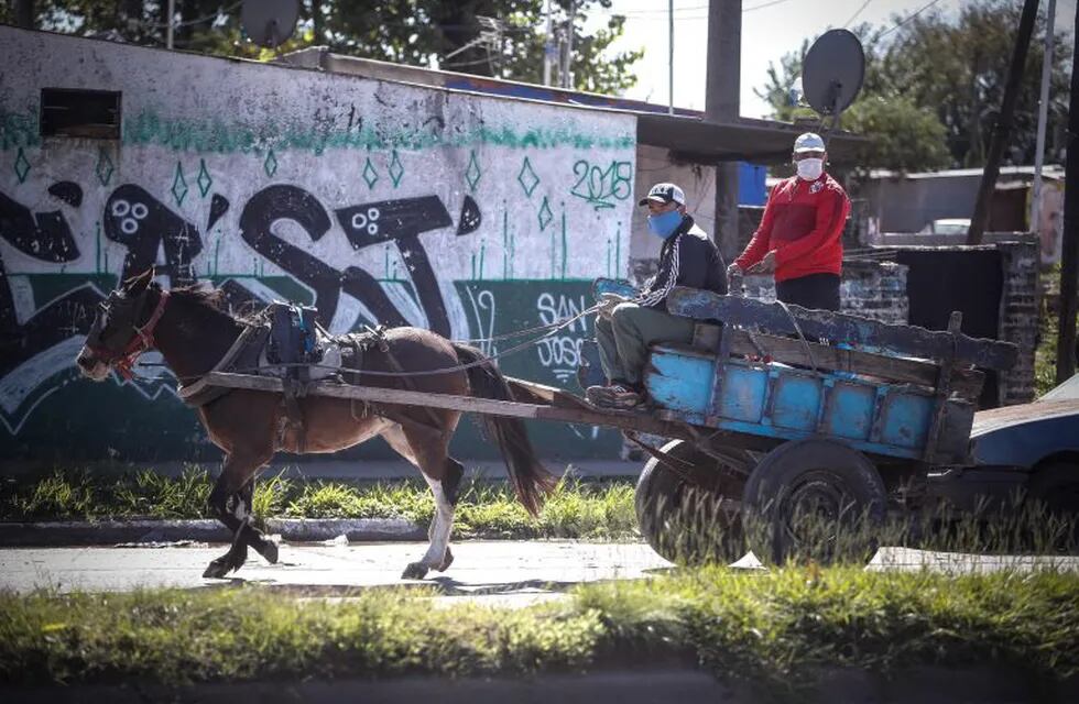 Personas con tapabocas circulan en un carro tirado por caballos en Buenos Aires (Foto: Juan Ignacio Roncoroni/EFE)