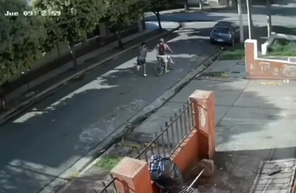 El momento en el que el ladrón tira al piso al hombre que viajaba a su trabajo en bicicleta.