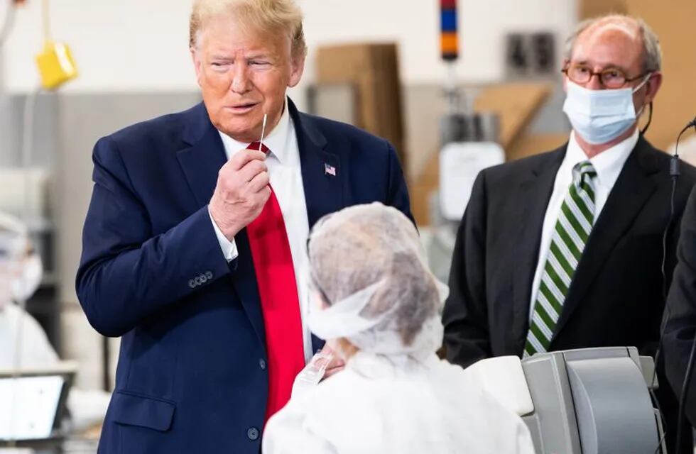 US President Donald Trump pretends to take a covid-19 test while holding a swab during his visit of the Puritan Medical Products facility in Guilford, Maine on June 5, 2020. (Photo by NICHOLAS KAMM / AFP)