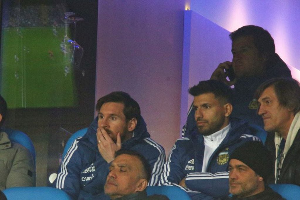 Sergio Agüero observa detenidamente, junto a Lionel Messi y otros miembros del cuerpo técnico, el partido entre la Selección Argentina e Italia en el Etihad Stadium de Manchester, Inglaterra. (AP Photo/Dave Thompson)