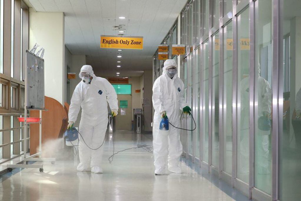 (Foto: Oficiales desinfectan habitaciones de estudiantes/EFE/EPA)