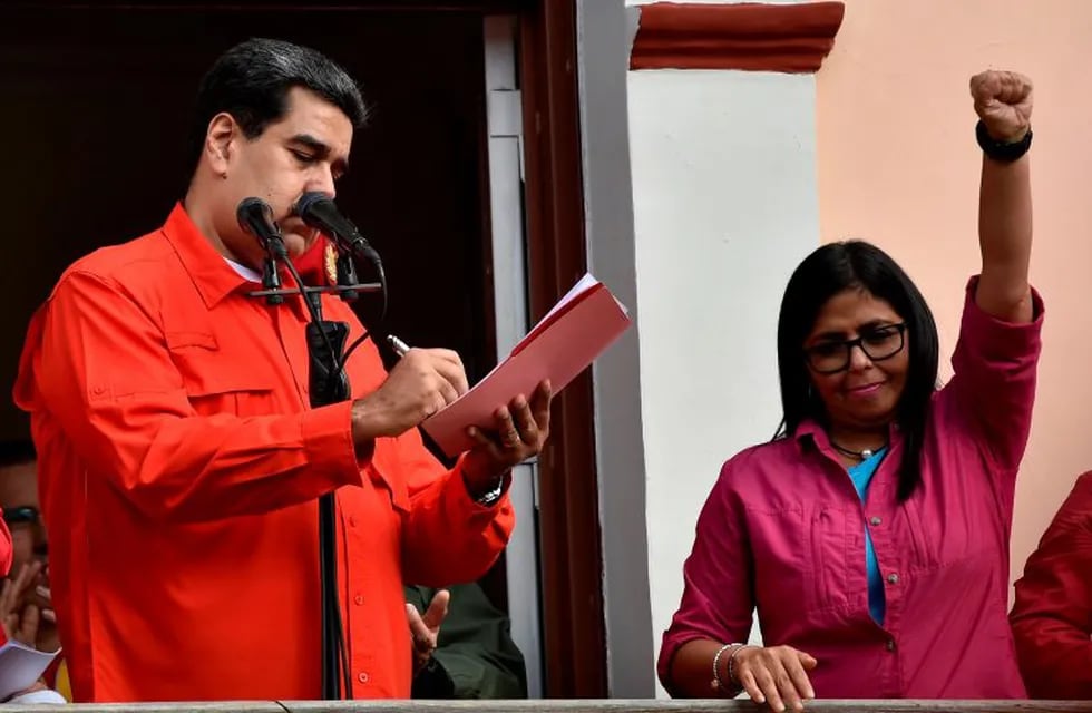 Venezuela's President Nicolas Maduro (L), next to Venezuelan Vice-president Delcy Rodriguez signs a document through which his government breaks off diplomatic ties with the United States, during a gathering in Caracas on January 23, 2019. - Venezuela President Nicolas Maduro announced on Wednesday he was breaking off diplomatic ties with the United States after counterpart Donald Trump acknowledged opposition leader Juan Guaido as the South American country's \