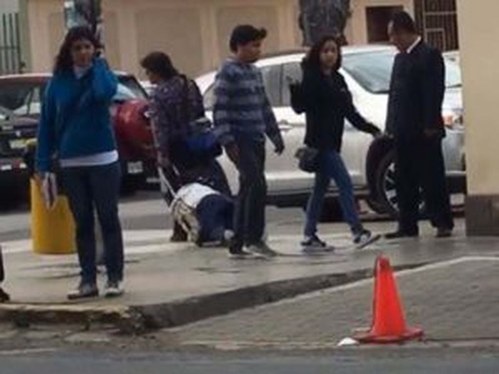 Una mujer arrastra a su hijo en una mochila con carro por las calles de Lima, Perú, sin llamar la atención de los transeúntes (Foto: Facebook/Alex Jara Esquivel )
