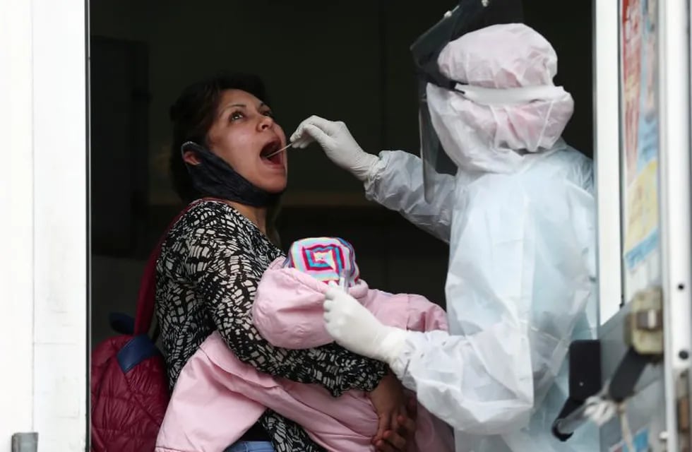 A medical staff member in protective suit takes a swab sample to test for the coronavirus disease (COVID-19), as part of the detectAR (detect) plan in Beccar, on the outskirts of Buenos Aires, Argentina June 17, 2020. REUTERS/Agustin Marcarian