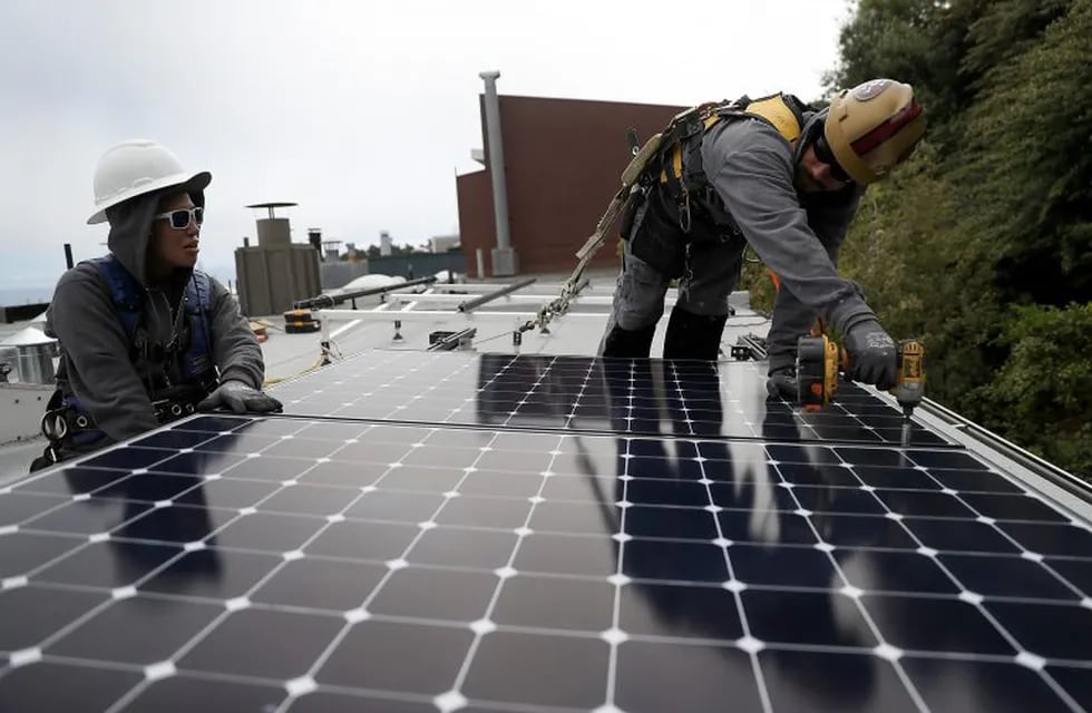 SAN FRANCISCO, CA - MAY 09: Luminalt solar installers Pam Quan (L) and Walter Morales (R) install solar panels on the roof of a home on May 9, 2018 in San Francisco, California. The California Energy Commission is set to vote on proposed legislation that would require all new homes in the state of California to have solor panels. If passed, the new mandate would require the panels on new homes up to three stories tall and is estimated to cost nearly $10K per home.   Justin Sullivan/Getty Images/AFP\r\n== FOR NEWSPAPERS, INTERNET, TELCOS & TELEVISION USE ONLY == eeuu california  California las casas nuevas deberan tener paneles solares energia solar paneles