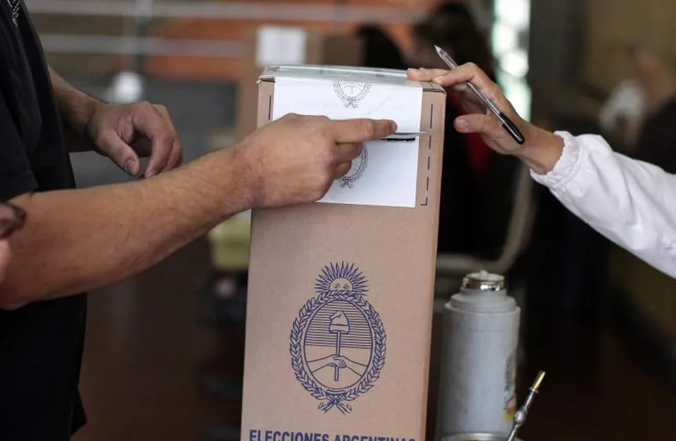 Un hombre deposita su voto en un colegio electoral en Buenos Aires. (Foto: EFE/David Fernández)