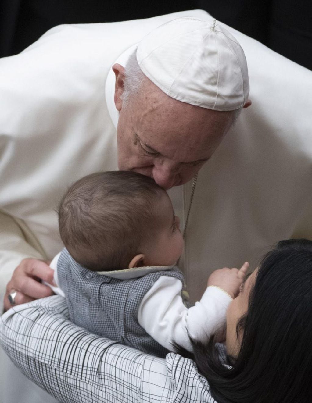 El papa Francisco besa a un bebé durante la audiencia general de los miércoles en el aula Pablo VI en el Vaticano. EFE/ Maurizio Brambatti