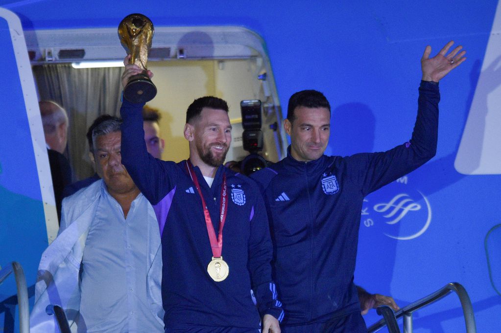 Lionel Messi, con la copa de campeón del mundo, acompañado por el DT Lionel Scaloni, al llegar a la Argentina. Foto: AP.