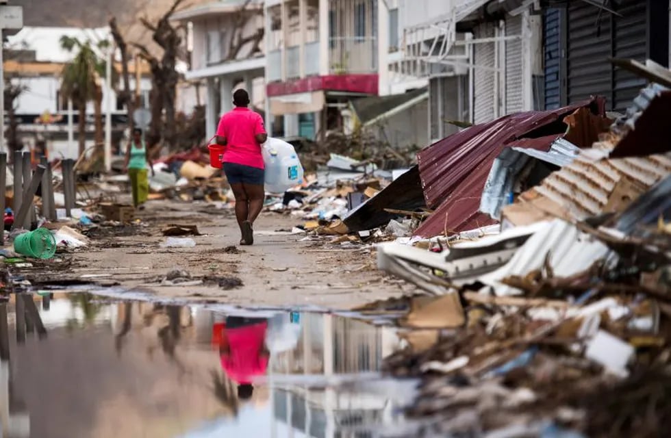 A woman walks on a street in Marigot, on September 11, 2017 on the French Caribbean island of Saint-Martin after it was hit by Hurricane Irma. / AFP PHOTO / Martin BUREAU