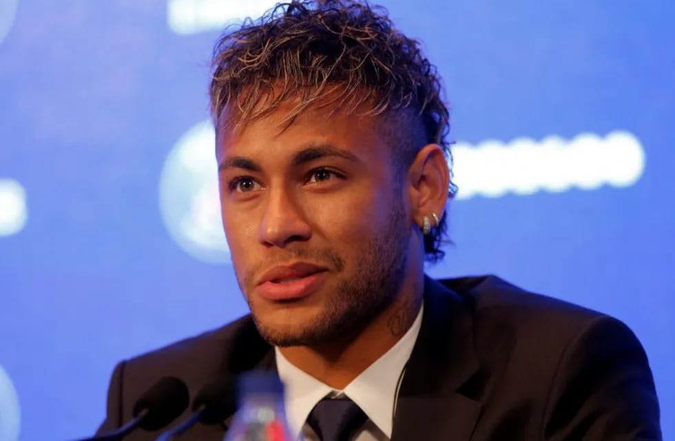 A man waiting for the arrival of Brazilian soccer star Neymar poses with a PSG shirt with Neymar's name on outside the Parc des Princes in Paris Friday, Aug. 4, 2017. Neymar arrived in Paris on Friday the day after he became the most expensive player in soccer history when completing his blockbuster transfer to Paris Saint-Germain from Barcelona for 222 million euros ($262 million).(AP Photo/Kamil Zihnioglu)