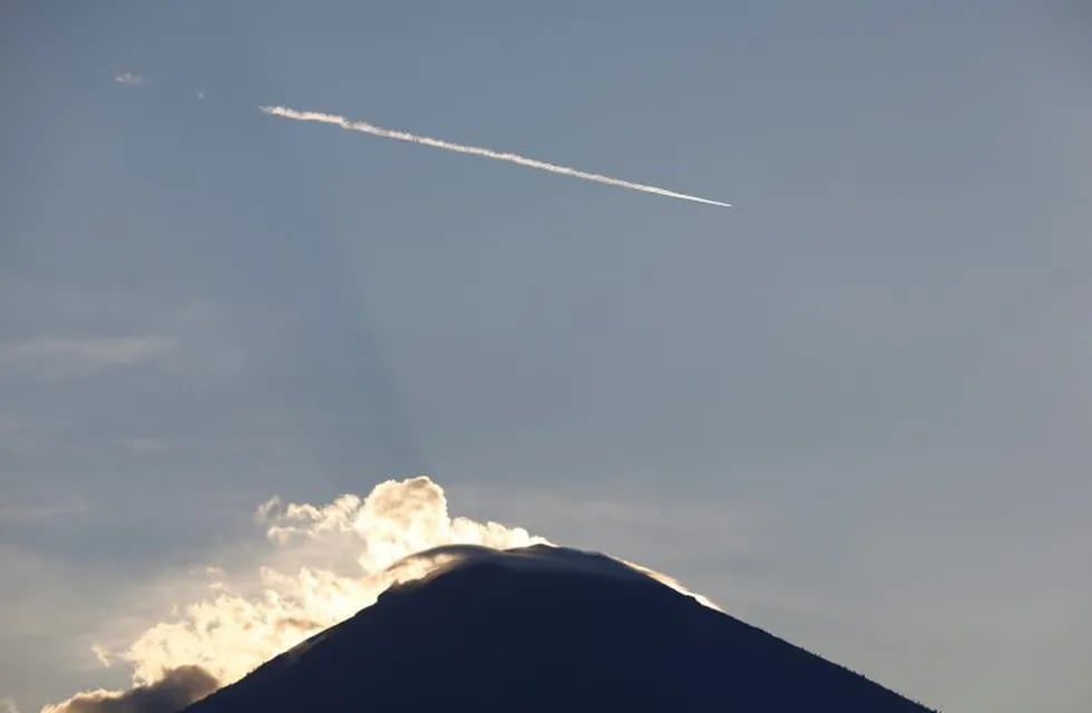 An airliner is seen flying above Mount Agung, a volcano on the highest alert level, from Amed on the resort island of Bali, Indonesia September 26, 2017. REUTERS/Darren Whiteside