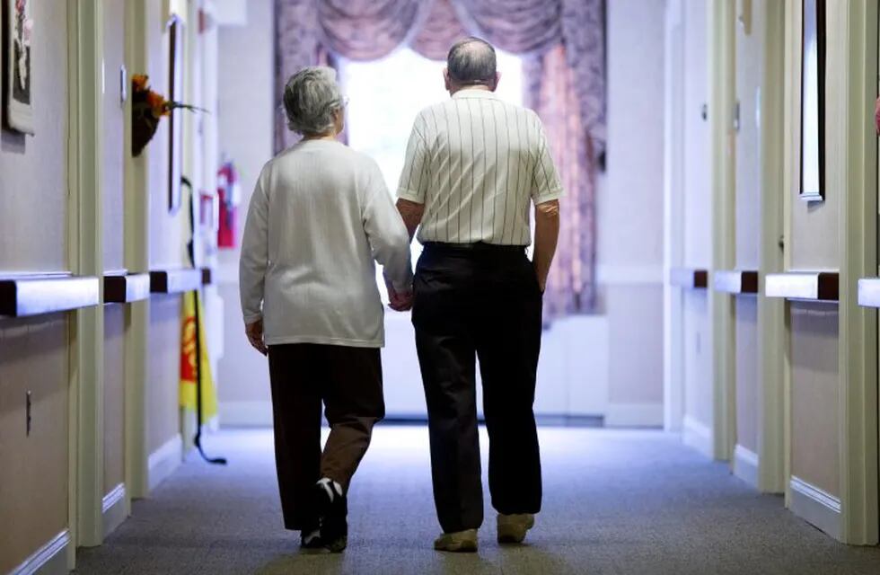 Decima Assise, who has Alzheimer's disease, and Harry Lomping walk the halls, Friday, Nov. 6, 2015, at The Easton Home in Easton, Pa. Nursing homes and assisted living facilities are increasingly using sight, sound and other sensory cues to stimulate memory in people with Alzheimer's disease and other forms of dementia. (AP Photo/Matt Rourke) eeuu easton Decima Assise Harry Lomping eeuu geriatrico para enfermos de alzheimer geriatrico con estimulacion visual y sonora para el tratamiento de pacientes con alzheimer