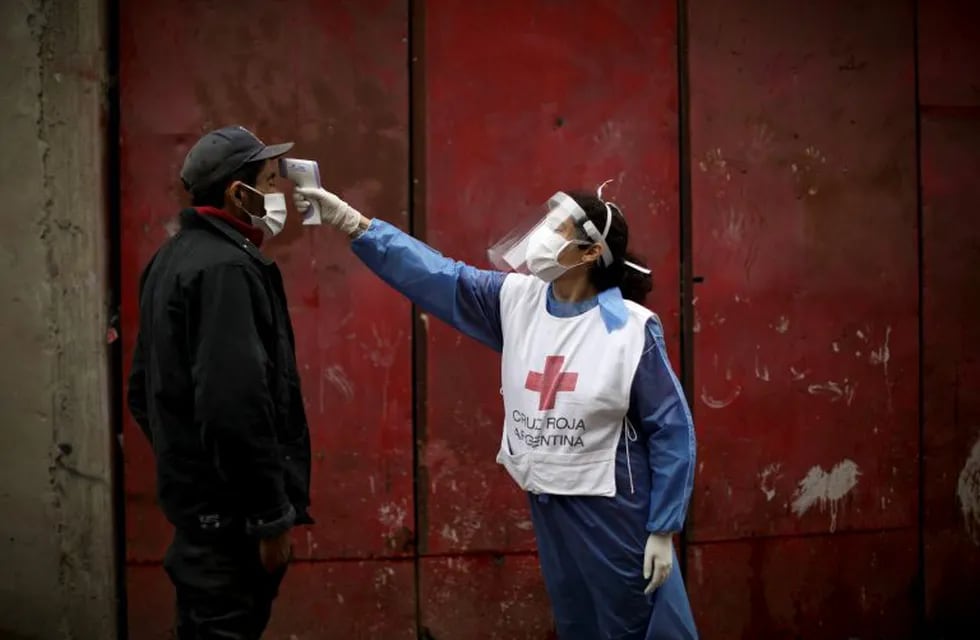 Voluntarios de la Cruz Roja toman la temperatura a un hombre (AP Photo/Natacha Pisarenko)