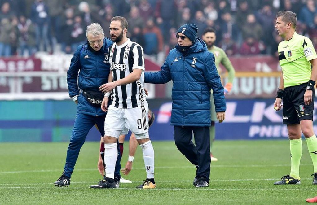 Juventus's Gonzalo Higuain, center, leaves the pitch after being injured during the Italian Serie A soccer match between Torino and  Juventus at Turin's Olympic Stadium, Italy, Sunday Feb.18, 2018. (Alessandro Di MArco/ANSA via AP)