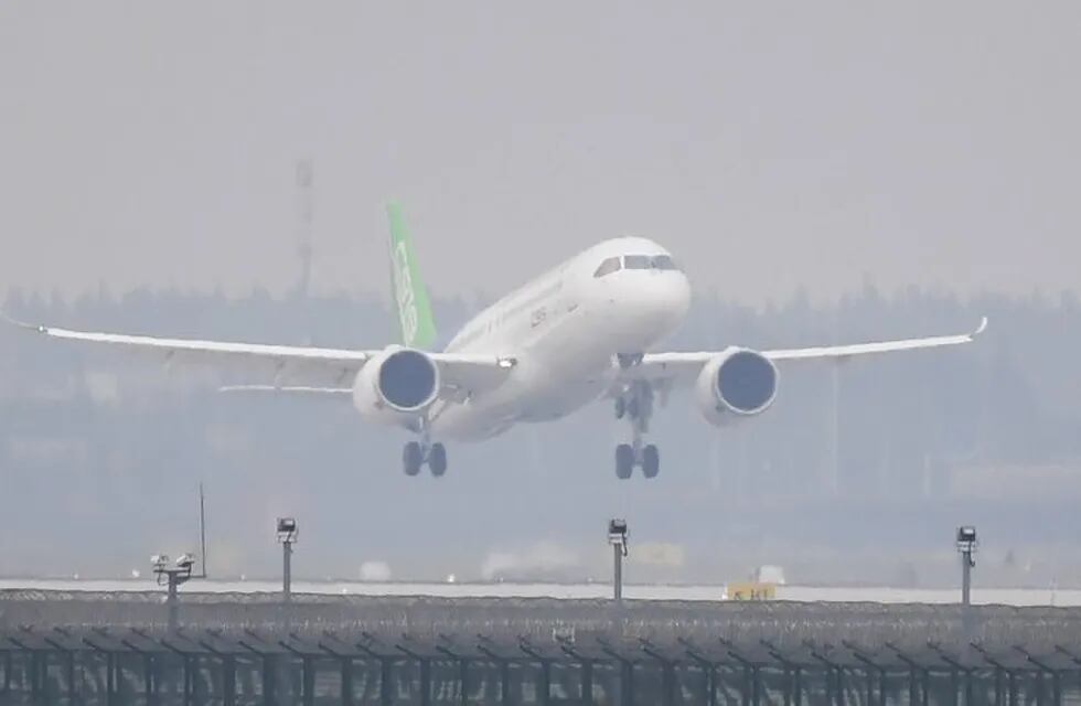 China's home-grown C919 passenger jet takes off from Pudong International Airport on its maiden flight in Shanghai on May 5, 2017.\r\nThe first large made-in-China passenger plane took off on its maiden test flight on May 5, marking a key milestone on the country's ambitious journey to compete with the world's leading aircraft makers. / AFP PHOTO / GREG BAKER china shanghai  china presentacion de avion C919 industria aeronautica
