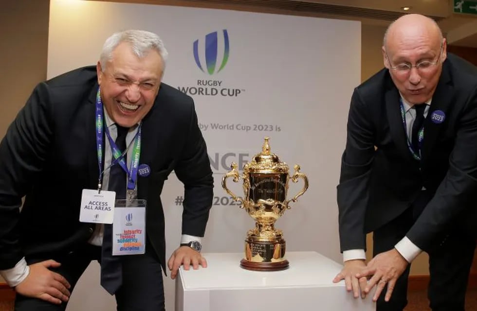 Claude Atcher Director of the French World Cup bid, left, and Bernard Laporte, President of the French Rugby Union pose for photographs after France won the right to host Rugby World Cup in 2023, with the Rugby World Cup trophy at a hotel in London, Wednesday, Nov. 15, 2017. Three competing countries South Africa, Ireland and France bid for the rights to hold the RWC in 2023, following the next RWC which will be held in Japan in 2019.(AP Photo/Alastair Grant)