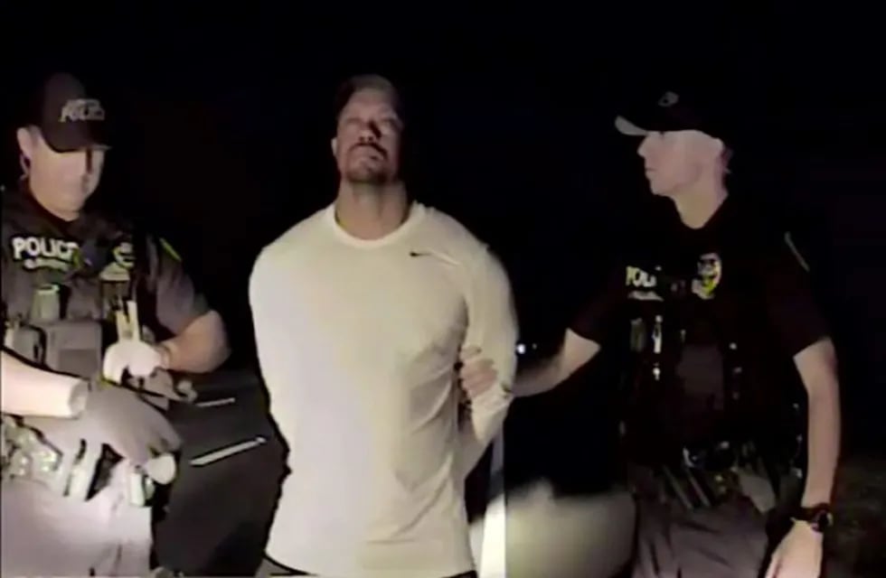 In this image taken from video golfer Tiger Woods stands between two police officers in Jupiter Florida Monday May 29,2017. Police in the US state of Florida have released video of professional golfer Tiger Woods' recent arrest. Jupiter Police released the dash-cam footage of the incident late on Wednesday May 31, 2017. Officers on patrol early on Monday noticed a Mercedes pulled awkwardly to the side of the road with the engine running, the brake lights on and a right indicator blinking. (Jupiter Police Department/via AP)