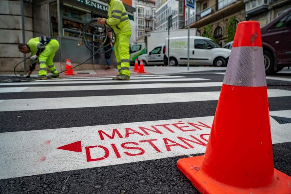 El ayuntamiento de Santander pinta sendas peatonales y regula semáforos para garantizar la distancia social entre peatones, este miércoles. (EFE/ Román G.aguilera)