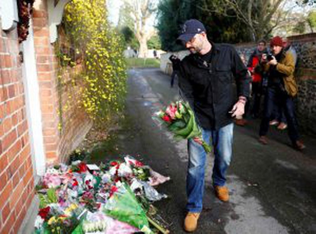A man carries flowers to the house of singer George Michael, where he died on Christmas Day, in Goring, southern England, Britain December 26, 2016.  REUTERS/Eddie Keogh